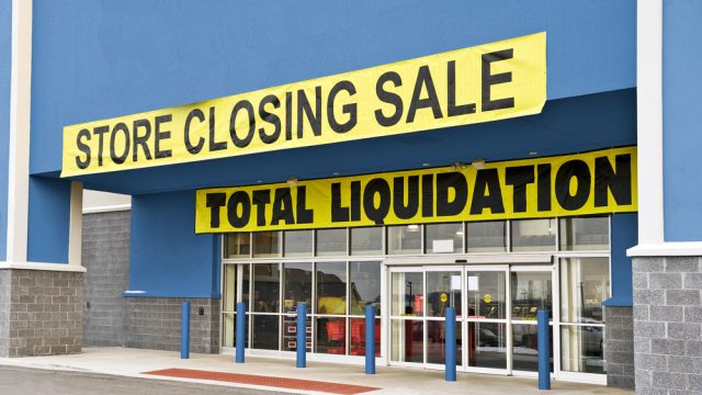 A storefront covered in going out of business signs