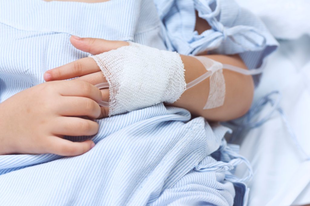 Hand of the sick child with saline solution with Space for text.