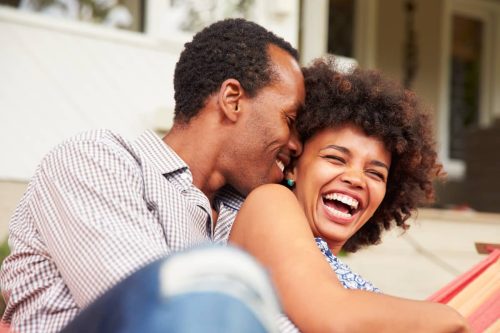 man and woman laughing on couch
