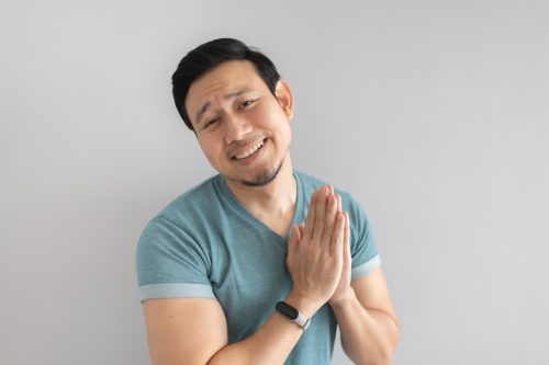man looking contrite against grey background