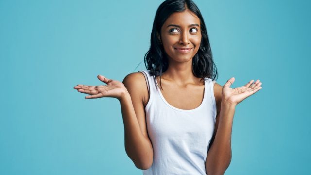 east asian woman smirking and shrugging
