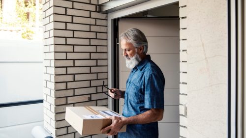 Mature man customer receiving parcel post box Sign signature by smartphone