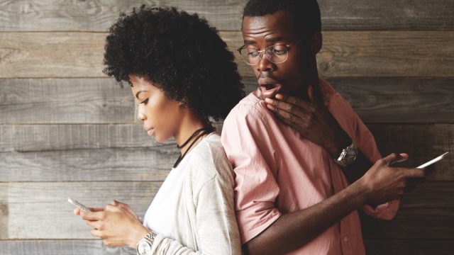 man looking at screen of girlfriend's phone