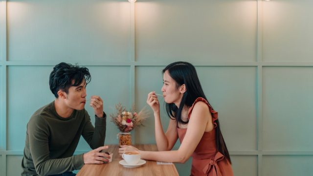 Young couple locking eyes in a cafe picture id1328009899
