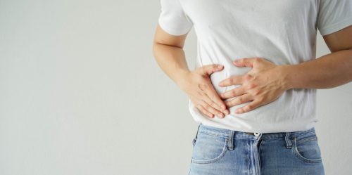 Adult man with his hands on his stomach.