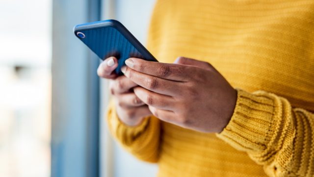 Shot of an unrecognizable woman using a mobile phone indoors