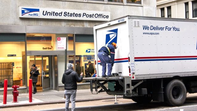 USPS postman on a mail delivery truck in New York. USPS is an independent agenc of US federal government responsible for providing postal service in the US.