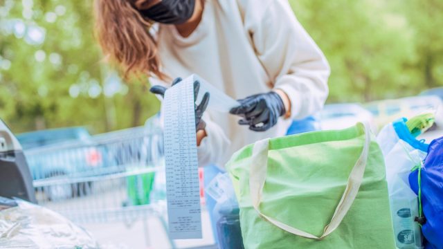 photo of young woman, she packing their groceries in her car