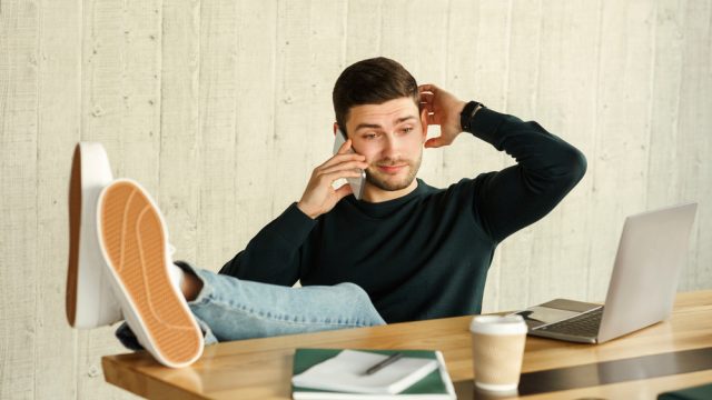 irresponsible man on the phone at his desk