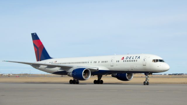 A Delta Air Lines plane sitting on the runway at an airport