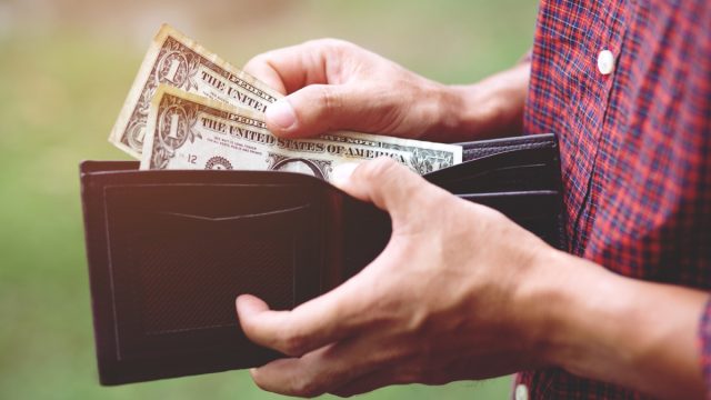 Erson holding an wallet in the hands of an man no money have a little money. Poverty poor Bankruptcy in concept.