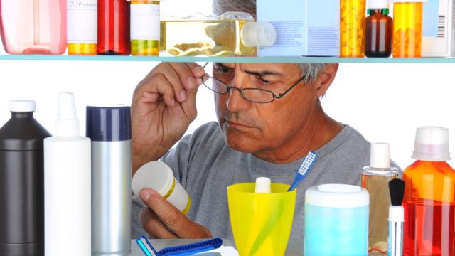 Unshaven,Middle,Aged,Man,Reading,A,Prescription,Label,In,Front