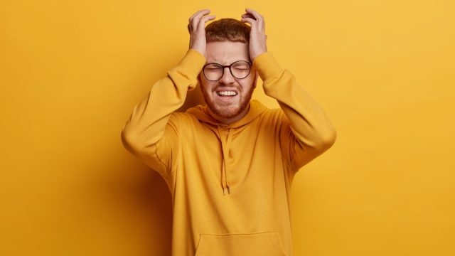 Man Grabbing the Side of His Head