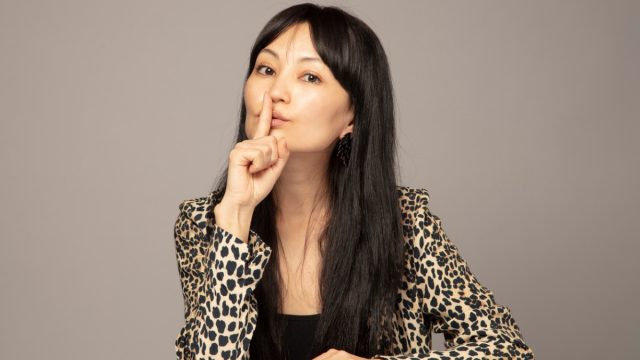 woman sshing camera with a secret
