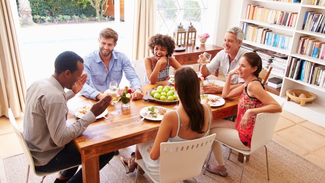 Friends sitting at a table talking during a dinner party