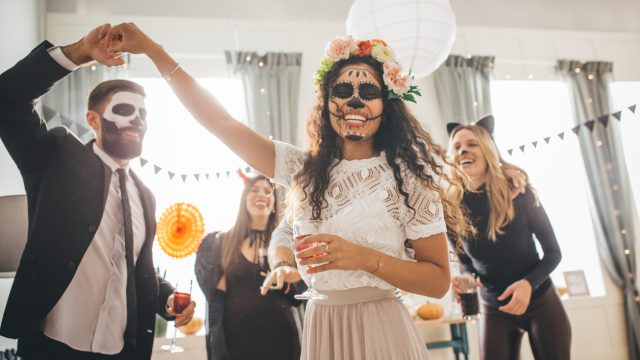 Group of Young people at home celebrating Halloween in costumes, they enjoy in good atmosphere
