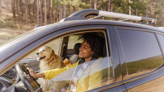 young black woman driving around with her dog