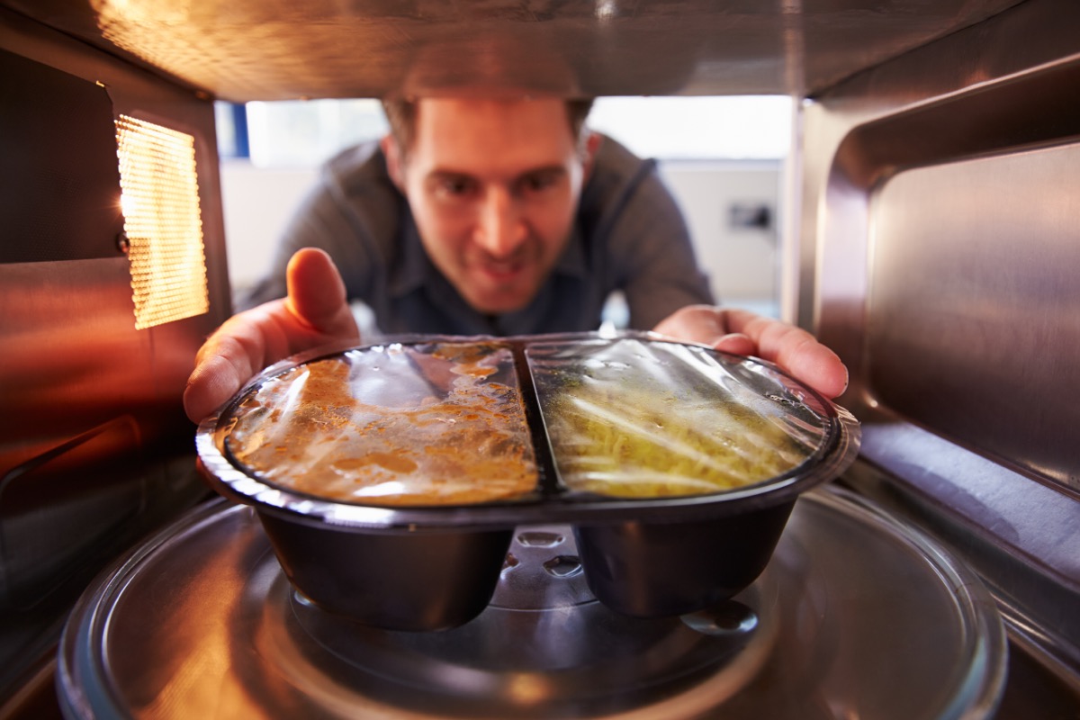 Man heating prepackaged dinner