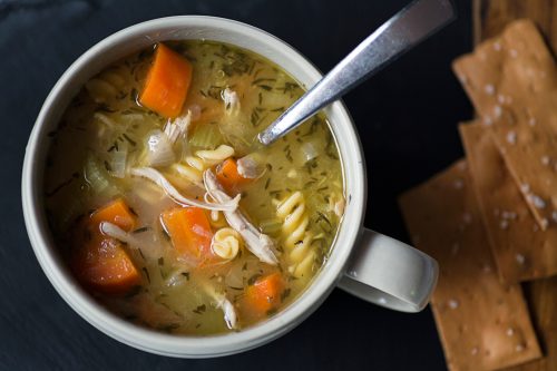 Homemade chicken noodle soup with carrots and crackers