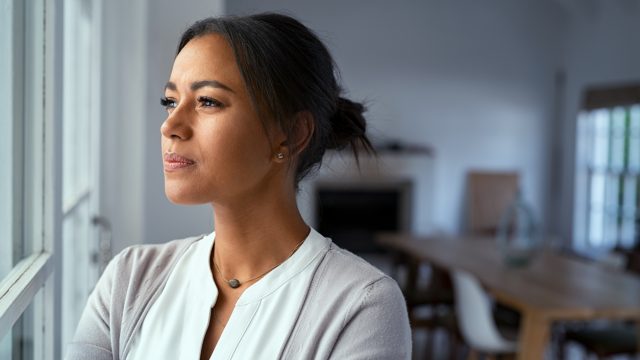 Thoughtful woman looking out of window.