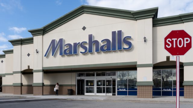 The exterior of a Marshalls store with a stop sign in the picture.
