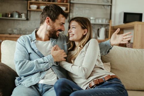couple sitting on a couch holding hands asking each other random questions