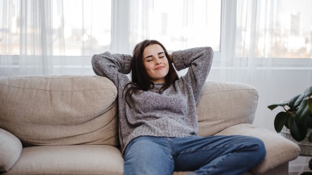woman leaning back on the couch alone
