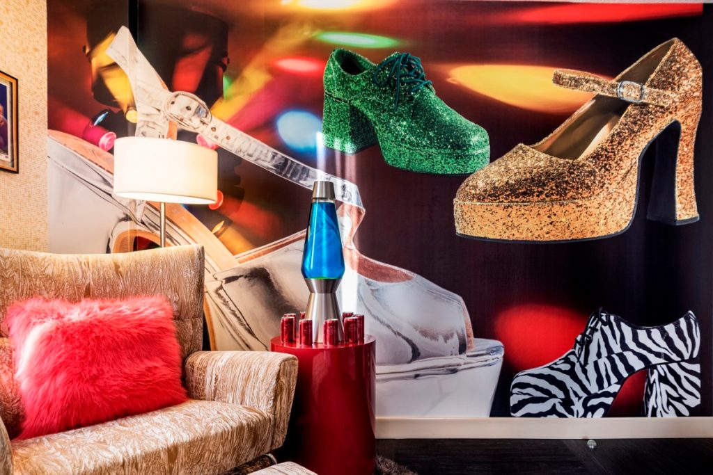 A chair next to a lava lamp and disco shoe wallpaper
