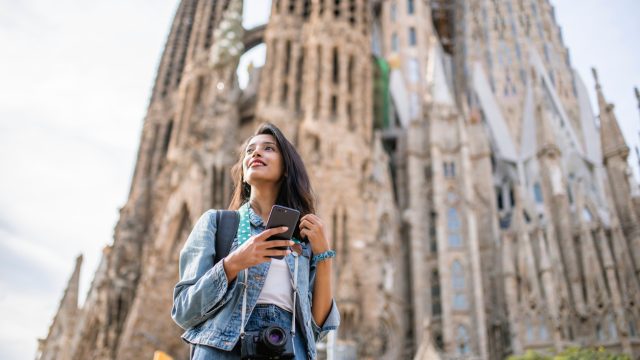 A woman standing in front of the Sagrada Familia cathedral