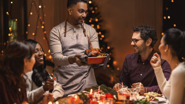 A multiethnic group of happy friends having Christmas dinner at home