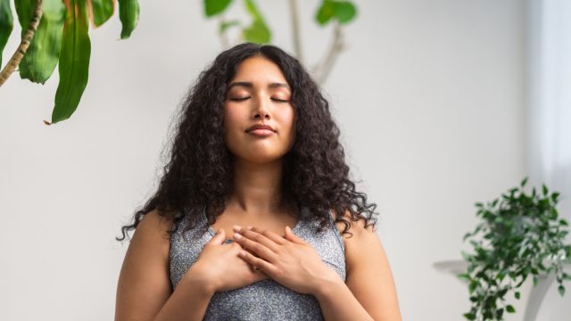 woman is doing breathing exercise at home.