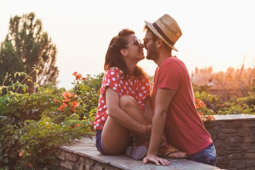 woman kissing her boyfriend on the balcony