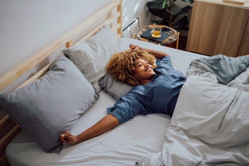 young black woman daydreaming in bed