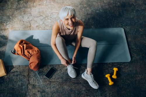 Athletic older woman with short hair in workout wear with weights
