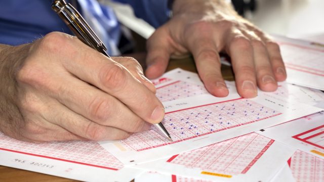 Close up of a person filling out lottery ticket numbers