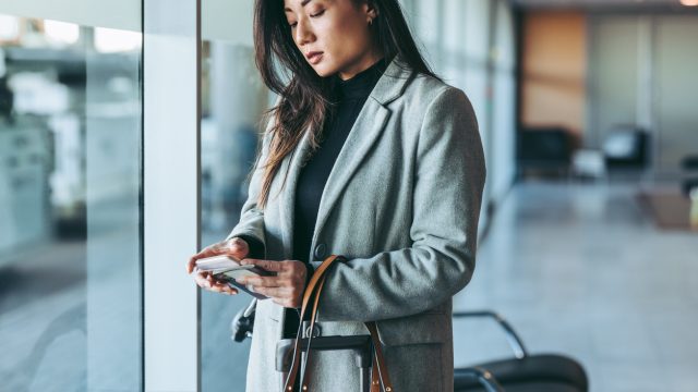 A woman using her phone in the airport