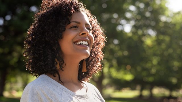 Happy woman smiling outside in nature.