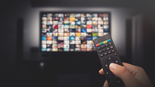 Watching a tv show with a remote controller.