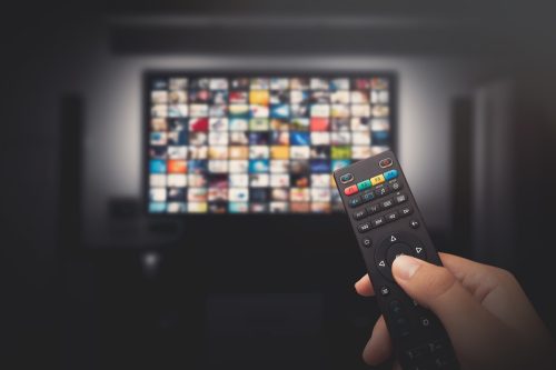 Watching a tv show with a remote controller.