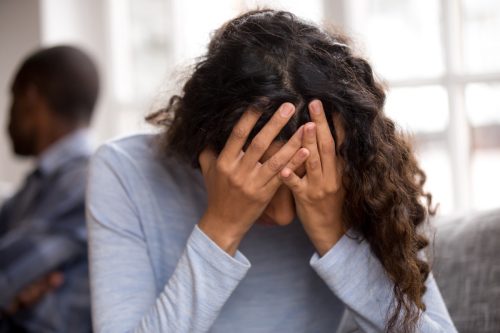 Woman with her hands in her head, frustrated with her partner.