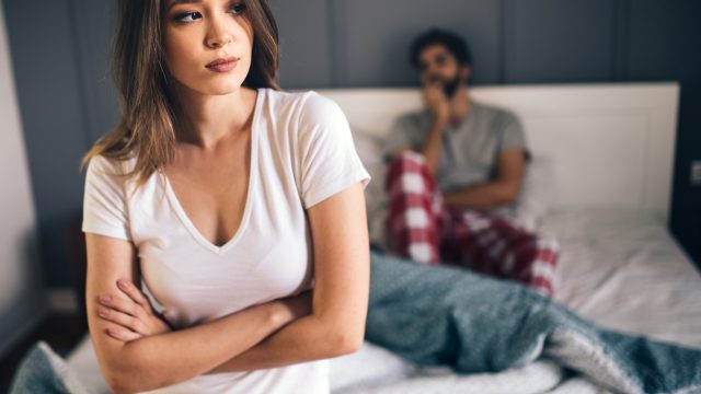 A young heterosexual couple having an argument in bed