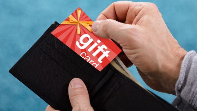 A closeup of a hand removing a gift card from a wallet