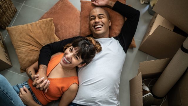 Happy young couple lying on the floor at new home