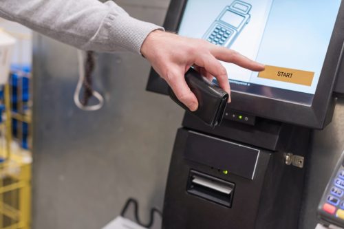 man paying at self-checkout