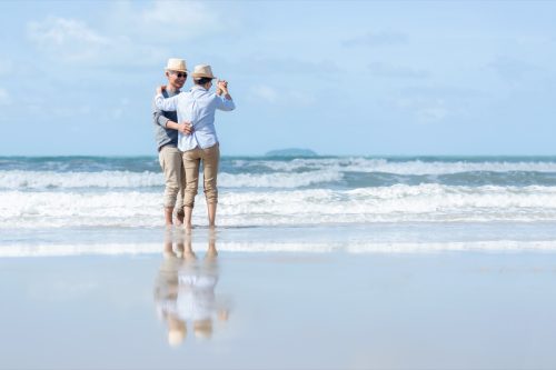 A couple dances on the beach together.