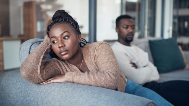 Cropped shot of a young couple sitting on the sofa and giving each other the silent treatment after an argument