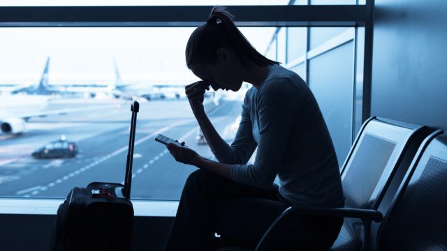 Woman airport distressed airlines canceled flights holiday storm.jpg