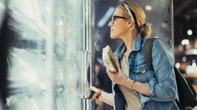 A woman shopping in the freezer section of a supermarket