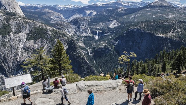 A group of tourists at Yosemite National Park looking over a viewpoint