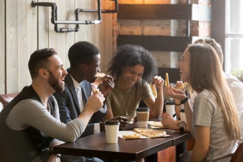Group of young people out at lunch laughing together.